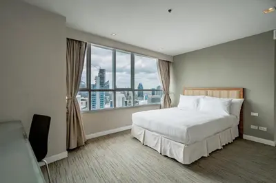 a bedroom with a large bed and a large window at Urbana Langsuan Hotel in Bangkok