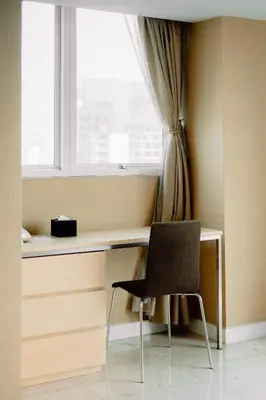 a desk with a chair in front of a window at Urbana Langsuan Hotel in Bangkok