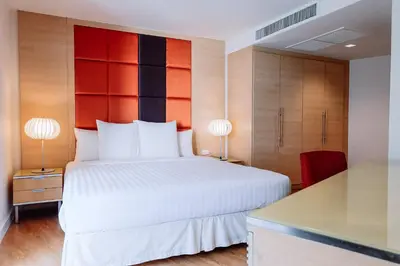 a bedroom with a large white bed and two lamps at Urbana Langsuan Hotel in Bangkok