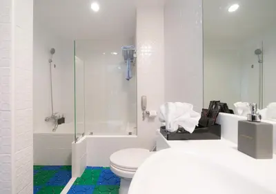 a white bathroom with a toilet and a shower at FuramaXclusive Asoke, Bangkok in Bangkok
