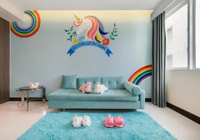 a living room with a blue couch with a rainbow mural at FuramaXclusive Asoke, Bangkok in Bangkok