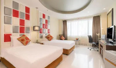 a hotel room with two beds and a desk at FuramaXclusive Asoke, Bangkok in Bangkok