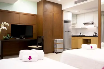 a hotel room with two beds and a kitchen at FuramaXclusive Sathorn, Bangkok in Bangkok