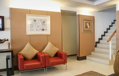 a waiting room with a red chair and stairs at FuramaXclusive Sathorn, Bangkok in Bangkok