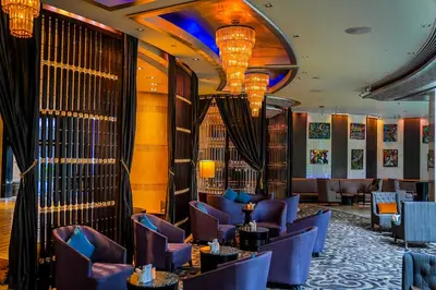 a hotel lobby with purple chairs and tables at Hilton Bangkok Grande Asoke in Bangkok