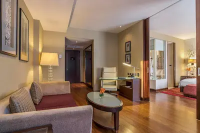 a living room with a couch and a table at Hilton Bangkok Grande Asoke in Bangkok