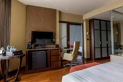 a hotel room with a bed and a television at Hilton Bangkok Grande Asoke in Bangkok