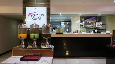 a restaurant with a counter with a coffee shop at Aspen Suites Hotel Sukhumvit 2 in Bangkok