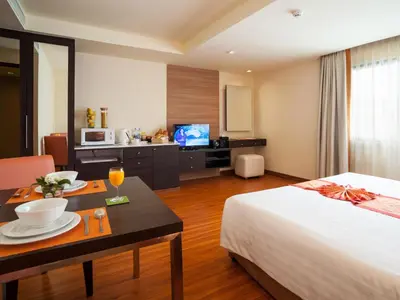 a hotel room with a bed and a table with a dining room at Aspen Suites Hotel Sukhumvit 2 in Bangkok