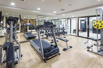 a gym with several treadmills and elliptical machines at Aspen Suites Hotel Sukhumvit 2 in Bangkok