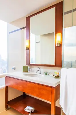 a bathroom with a sink and a large mirror at Column Bangkok Hotel in Bangkok