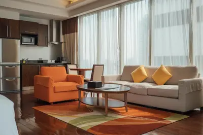 a living room with a couch and two chairs and a table at Column Bangkok Hotel in Bangkok
