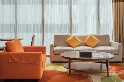 a living room with a couch and a table at Column Bangkok Hotel in Bangkok