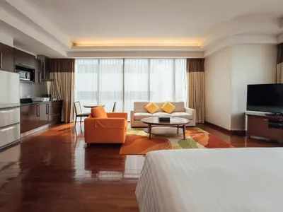 a living room with a couch and a table at Column Bangkok Hotel in Bangkok