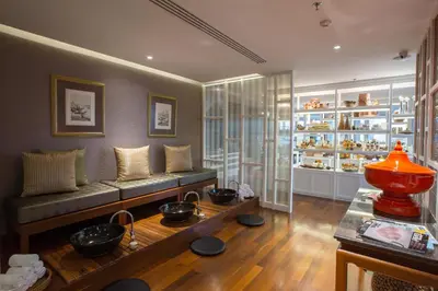 a living room with a couch and bowls on a table at Grande Centre Point Ploenchit in Bangkok