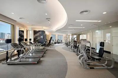 a gym with rows of treadmills and machines at Grande Centre Point Hotel Ratchadamri Bangkok in Bangkok