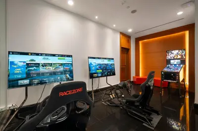 a gym with two monitors and a video game at Grande Centre Point Hotel Ratchadamri Bangkok in Bangkok
