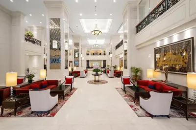 a lobby of a hotel with red couches and chairs at Grande Centre Point Hotel Ratchadamri Bangkok in Bangkok