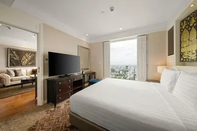 a hotel room with a large bed and a television at Grande Centre Point Hotel Ratchadamri Bangkok in Bangkok