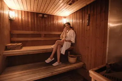 a woman is sitting in a sauna at Centre Point Sukhumvit Thong-Lo in Bangkok