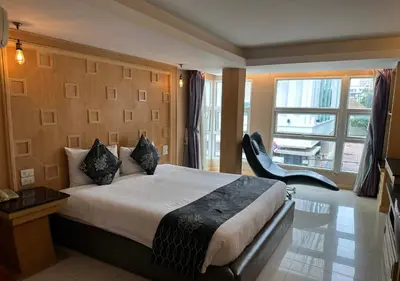 a bedroom with a bed and a chair and a window at UPAR Hotels Sukhumvit 11 Nana in Bangkok