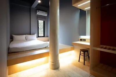 a small room with a bed and a window at CLOUD on Saladaeng Silom Hostel Bangkok in Bangkok