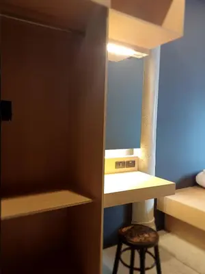 a small room with a mirror and a stool at CLOUD on Saladaeng Silom Hostel Bangkok in Bangkok