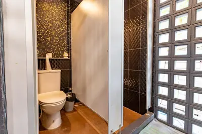 a bathroom with a toilet and a shower at CLOUD on Saladaeng Silom Hostel Bangkok in Bangkok