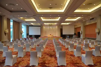 a conference room with white chairs and a podium at Rama Gardens Hotel Bangkok in Bangkok