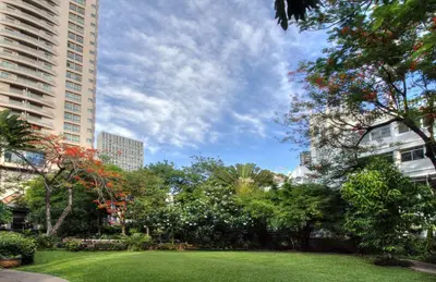 a park in the middle of a city with tall buildings at Somerset Park Suanplu Bangkok in Bangkok