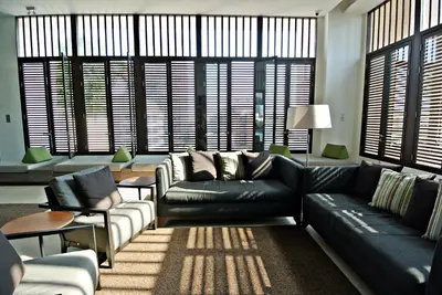 a living room with a black leather couch and chairs at Somerset Park Suanplu Bangkok in Bangkok