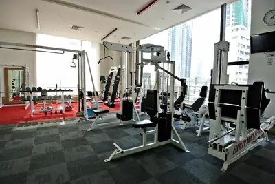 a gym with tread machines and a large window at Somerset Park Suanplu Bangkok in Bangkok