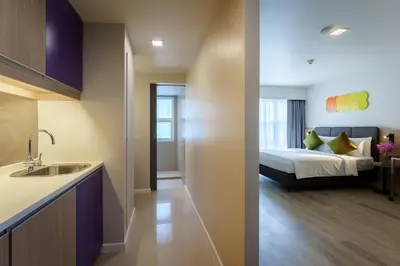 a kitchen and a bedroom with a bed in a room at Citadines Sukhumvit 16 Bangkok in Bangkok