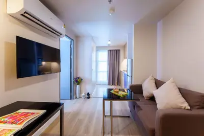 a living room with a couch and a table at Citadines Sukhumvit 16 Bangkok in Bangkok