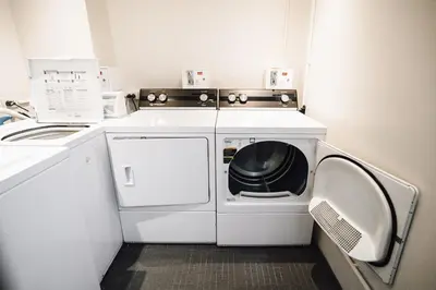 a white washer and dryer in a small room at Citadines Sukhumvit 16 Bangkok in Bangkok