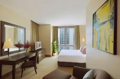 a hotel room with a bed and a desk with a desk at Ascott Sathorn Bangkok in Bangkok
