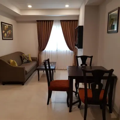a living room with a table and a couch at Club Mahindra Mac Boutique Hotel in Bangkok