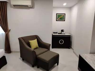 a living room with a chair and a table at Club Mahindra Mac Boutique Hotel in Bangkok