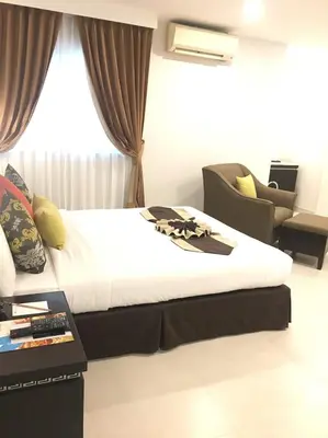 a hotel room with a bed and a chair at Club Mahindra Mac Boutique Hotel in Bangkok
