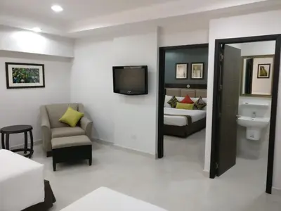 a room with a bedroom with a bed and a tv at Club Mahindra Mac Boutique Hotel in Bangkok