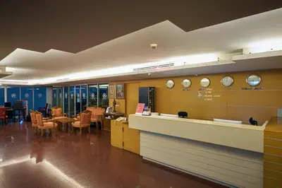 a waiting room with tables and clocks on the wall at Nana Hiso Hotel in Bangkok