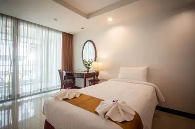 a bedroom with a bed and a desk and a mirror at Nana Hiso Hotel in Bangkok
