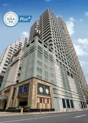 a tall building with a clock on the front of it at The Duchess Hotel in Bangkok