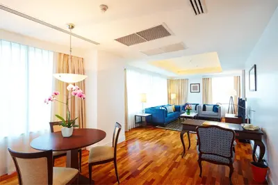 a living room with a table and a dining room at The Duchess Hotel in Bangkok
