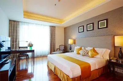 a hotel room with a bed and a desk at The Duchess Hotel in Bangkok