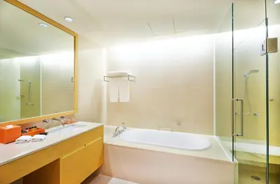 a bathroom with a tub and a shower and a sink at The Duchess Hotel in Bangkok
