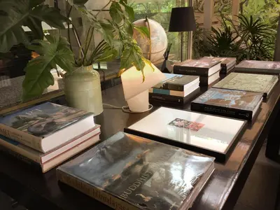 a table topped with books on top of a table at Refillnow! Hostel in Bangkok