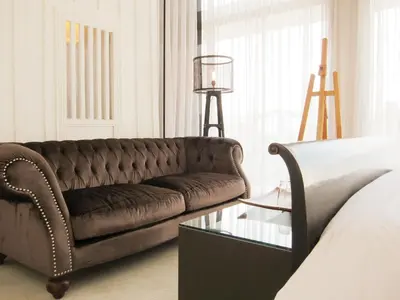 a living room with a brown couch and a glass table at Refillnow! Hostel in Bangkok