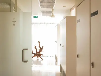 a room with white walls and a large antler on the wall at Refillnow! Hostel in Bangkok
