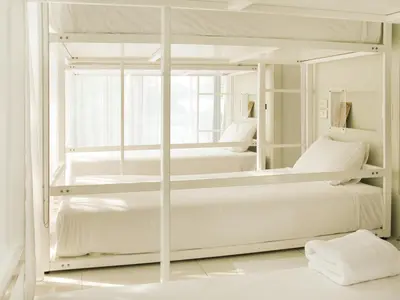 two bunk beds in a white bedroom with a window at Refillnow! Hostel in Bangkok
